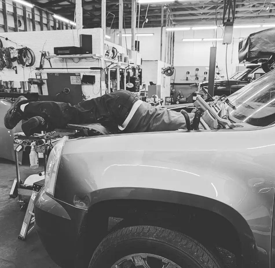 Engine Repair Technician Working Under Hood Technician performing engine diagnostics and repair work at NorthState Auto Clinic in Marysville.
